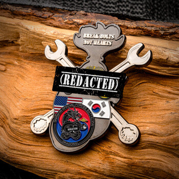 Custom cut-out challenge coin shaped with crossed wrenches, American and South Korean flags, a dragon insignia, and the phrase Break Bolts Not Hearts.