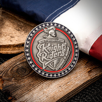 42d Transportation Knight Riders challenge coin featuring a knight helmet, silver star border, and red enamel accent displayed on wood with an American flag.