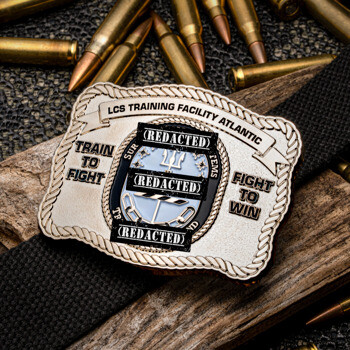 Rectangular custom belt buckle style challenge coin for LCS Training Facility Atlantic, with 'Train to Fight' and 'Fight to Win' text on a bed of ammunition.