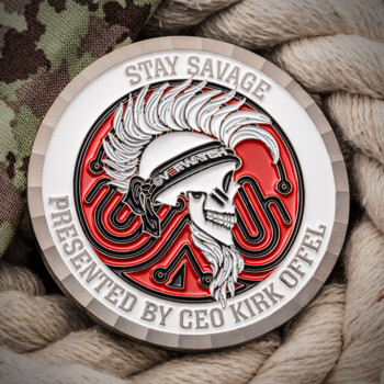 Stay Savage challenge coin featuring a mohawk skull wearing an Overwatch headband on a red and black background with a diamond cut edge.