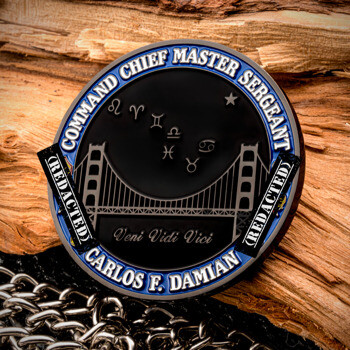 Custom challenge coin featuring a bridge design, zodiac symbols, and the name Carlos F. Damian set against a wooden backdrop.