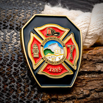 Shield-shaped firefighter challenge coin with a Maltese cross design featuring City of Morganton North Carolina, established 1885.