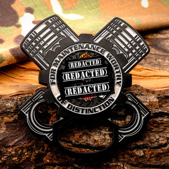 Custom engine-shaped challenge coin and bottle opener with pistons and gears, featuring the text For Maintenance Worthy of Distinction.