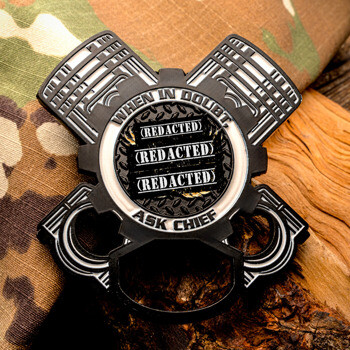 Engine-shaped cut-out challenge coin with a gear border, text reading 'When In Doubt, Ask Chief', and a black and silver finish on camo background.