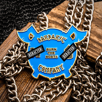 Barbaric Company custom enamel medallion on a thick metal chain over a rustic wood background.