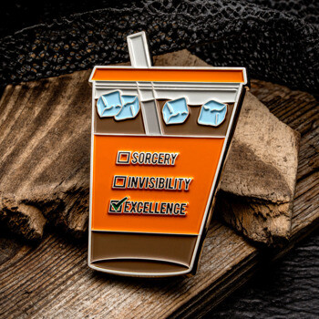 Custom lapel pin shaped like an iced coffee cup with a checklist for Sorcery, Invisibility, and Excellence.
