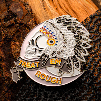 Treat 'Em Rough challenge coin featuring a skull wearing a Native American feathered headdress, resting on wood and mesh texture.