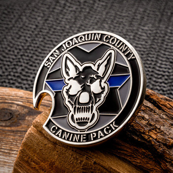 San Joaquin County Canine Pack challenge coin bottle opener with a silver German Shepherd skull design and thin blue line stripe detail on a wood block.