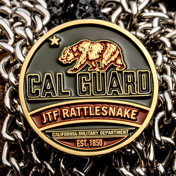 Cal Guard JTF Rattlesnake challenge coin featuring the California grizzly bear and gold rim against metal chains.