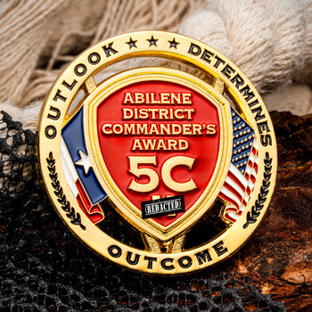 Gold challenge coin featuring Abilene District Commander's Award 5C with Texas and US flags, inscribed with Outlook Determines Outcome.