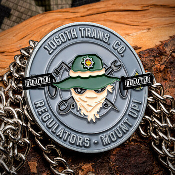 1060th Trans. Co. challenge coin with soldier emblem in green hat over crossed wrenches, displayed on chain and wood.