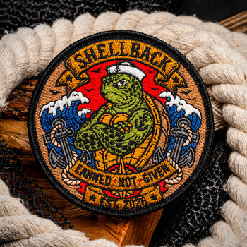Embroidered patch featuring a Shellback sea turtle in a sailor hat with anchors and ocean waves framed by nautical rope.