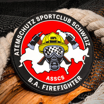 Circular Atemschutz Sportclub Schweiz embroidered patch featuring a firefighter helmet, mask, and crossed axes against a red and white background.