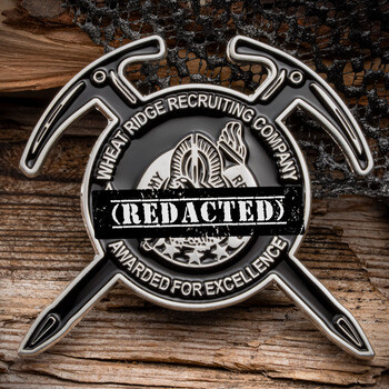 Custom challenge coin framed by crossed climbing picks with Wheat Ridge Recruiting Company text and silver accents.