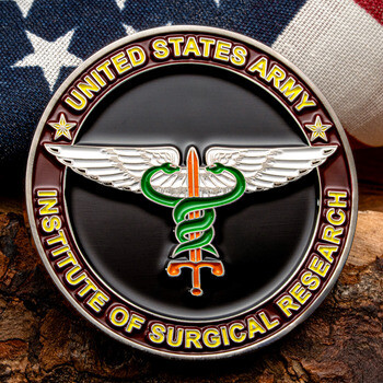 United States Army Institute of Surgical Research challenge coin featuring a winged caduceus over an American flag and wood bark background.