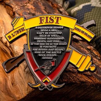 Shield-shaped military challenge coin for FIST B 1/78th featuring artillery symbols and a battle creed on a piece of wood.