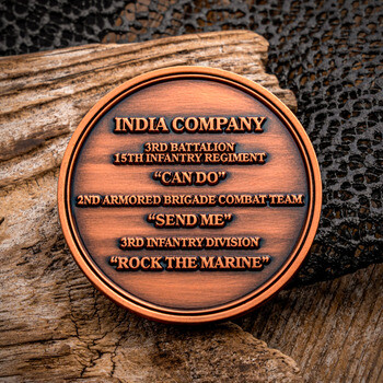 Antique bronze round challenge coin for India Company 3rd Battalion 15th Infantry Regiment resting on weathered wood.
