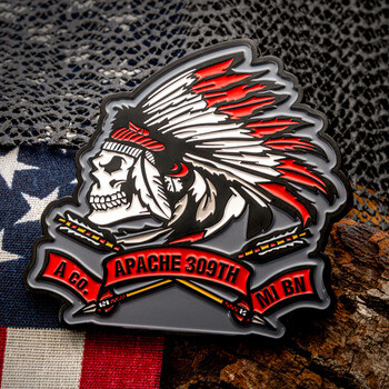 A Co. Apache 309th MI BN custom PVC patch or lapel pin featuring a skull wearing a feathered headdress over crossed arrows.