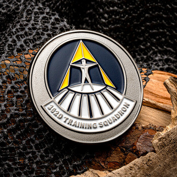 362D Training Squadron round challenge coin featuring a silver figure standing on a curved pedestal against a navy and yellow emblem.