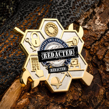 Hexagonal gold challenge coin with crossed tools, silver honeycomb cells featuring various trade icons, and a central circular insignia.