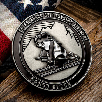 Antique silver military challenge coin featuring a skiing panda for 1st Squadron 89th Cavalry Regiment Pando Recon beside an American flag.