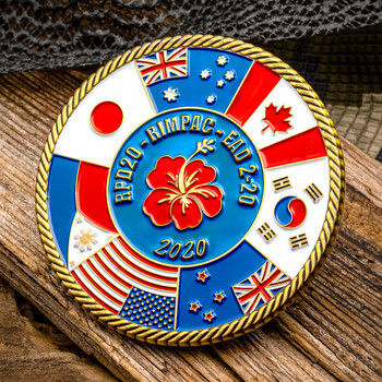 RIMPAC 2020 military challenge coin featuring international flags and a central red hibiscus flower with a rope-edge border.